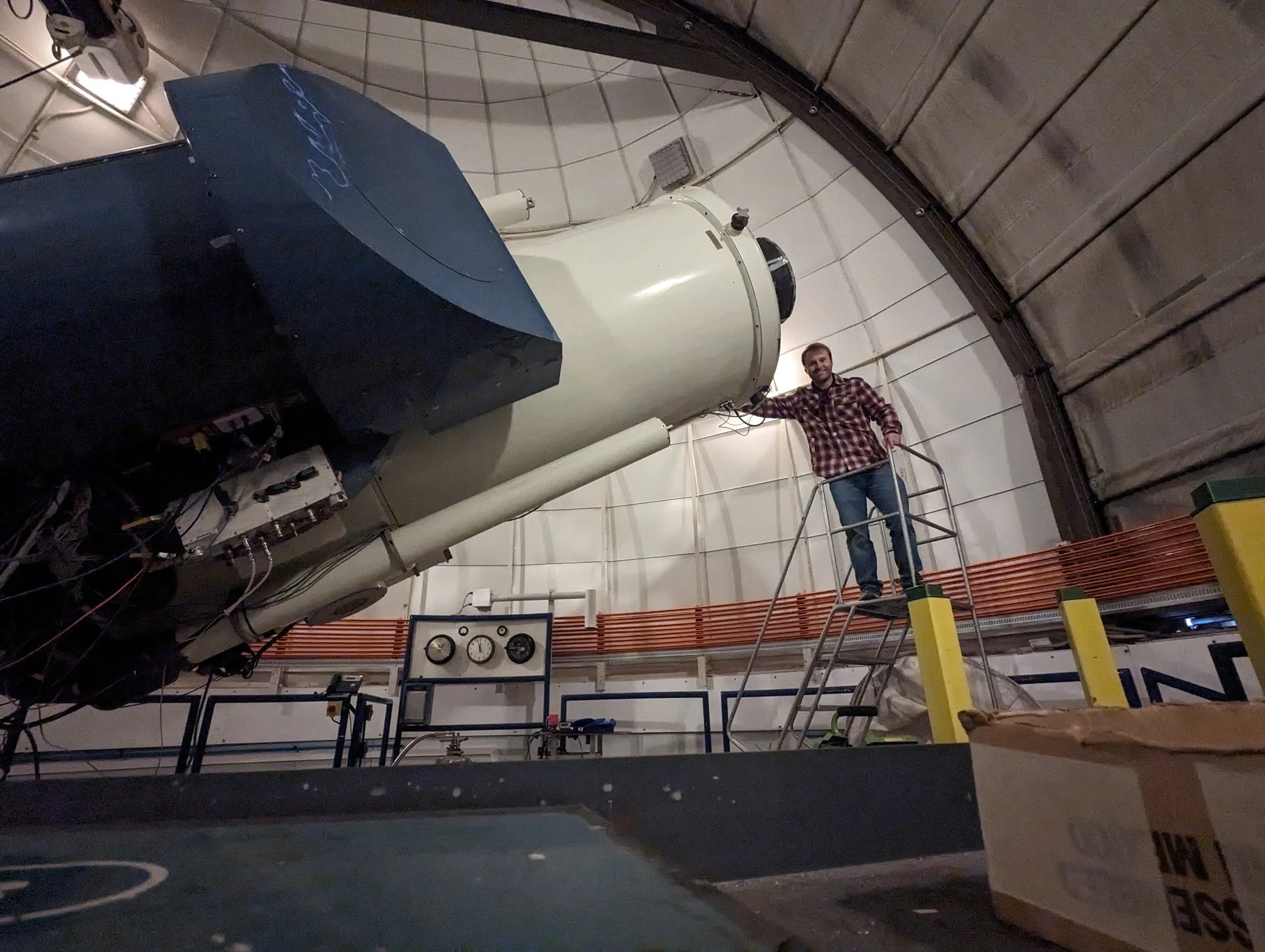 Cameron Pfeffer posing with the Henrietta Swope 1-m telescope at Las Campanas Observatory in Chile